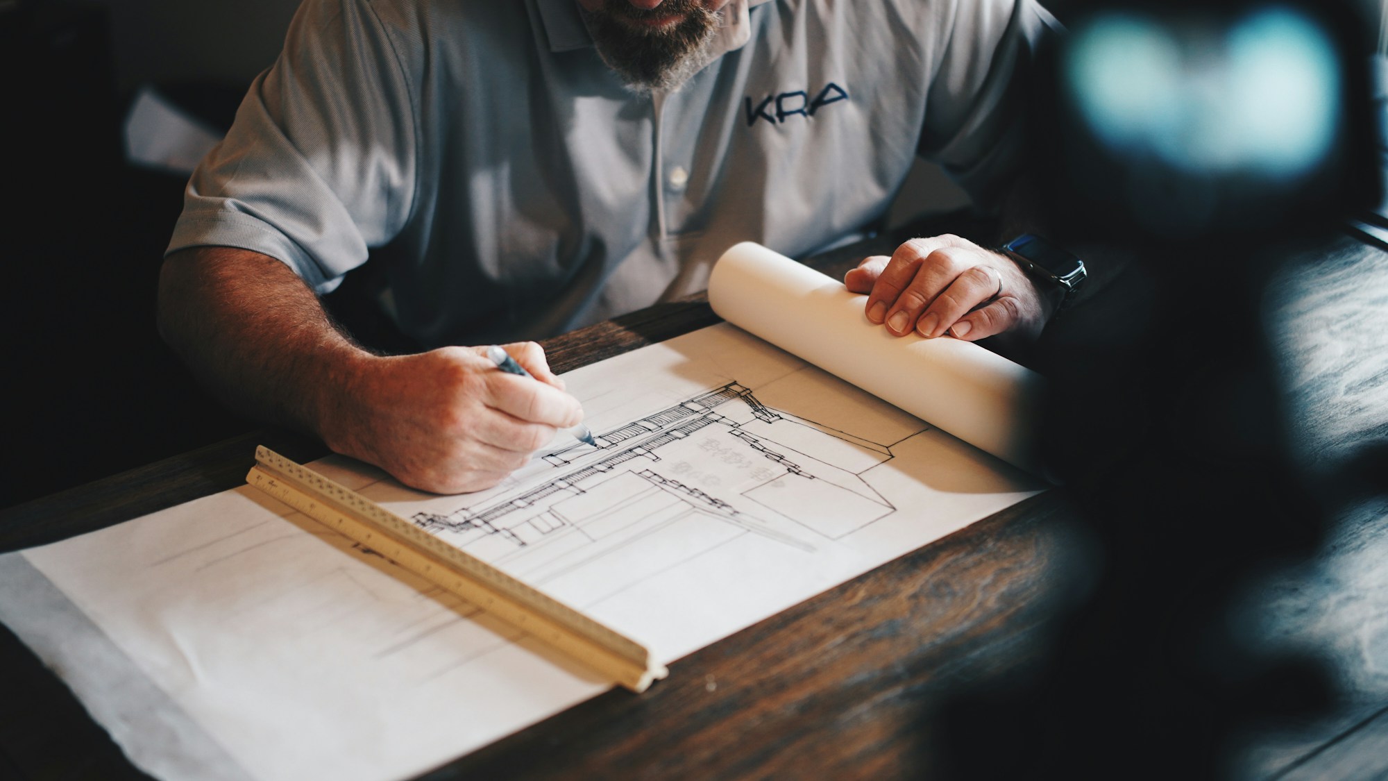 Professional reviewing architectural drawings at a work table